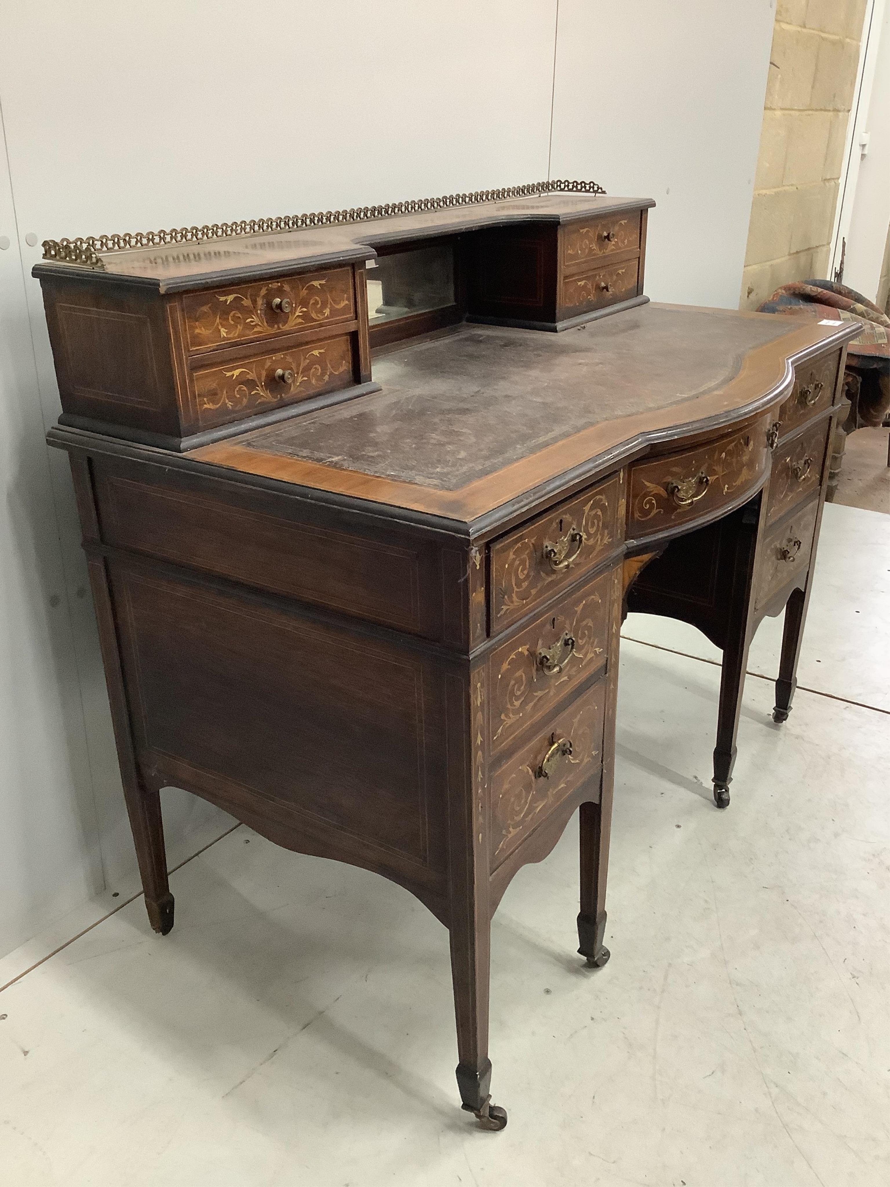 An Edwardian marquetry inlaid rosewood bowfront kneehole desk in the manner of Edwards and Roberts, width 110cm, depth 62cm, height 95cm. Condition - poor to fair